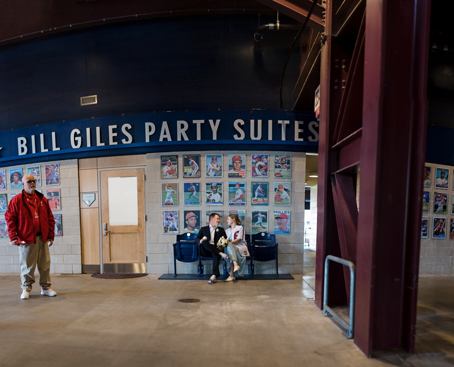 A bride and groom talking outside of their reception at a Phillies game.
